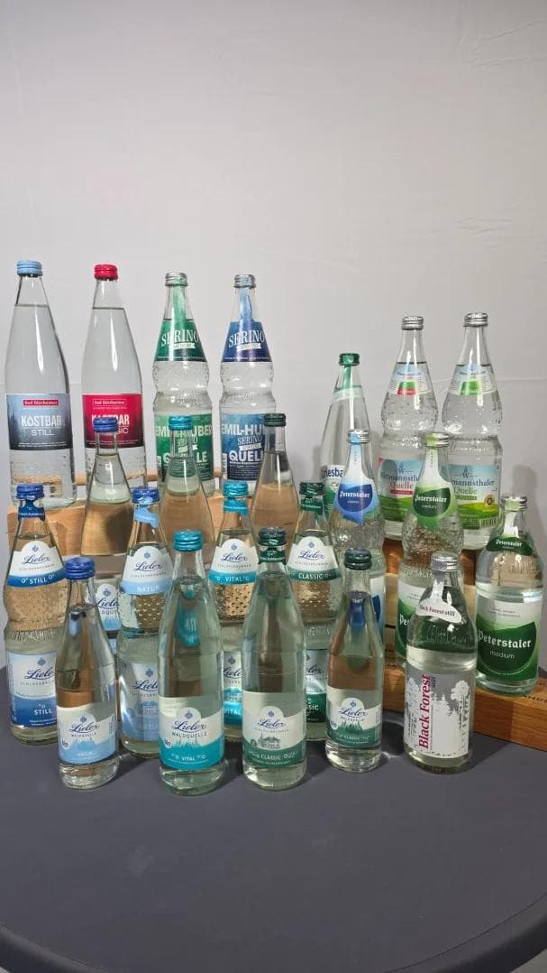 Verschiedene Flaschen mit Mineralwasser auf einem Tisch angeordnet.